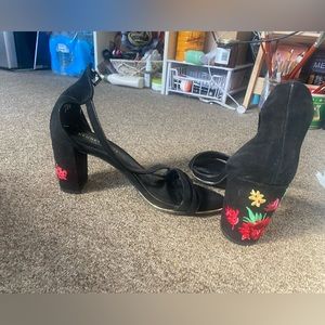 Black Kenneth Cole heels with flower detail on the heels.